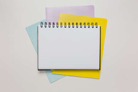 Notepad and exercise book on the desk. Mock up in copy space office on white background. Back to...