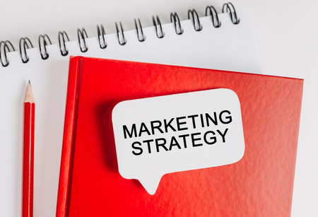 Text Marketing Strategy on a white sticker with office stationery background. Flat lay on business, finance and development conceptの写真素材