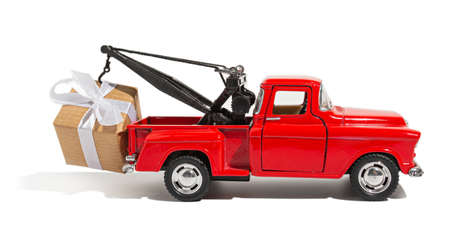Red pickup car carrying a gift for the holiday on a white isolated background. New year and christmas conceptの写真素材