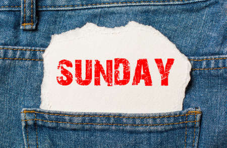 Sunday on white paper in the pocket of blue denim jeansの写真素材