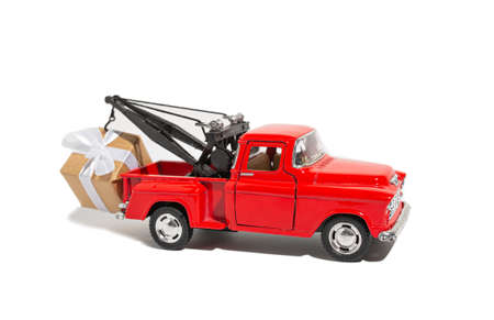 Red pickup car carrying a gift for the holiday on a white isolated background. New year and christmas conceptの写真素材