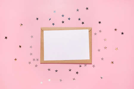 Empty card and confetti stars pours on a pastel pink background, top view. Flat lay. Holiday, greeting or good news concept. Mockup template. top view. Blank flyerの写真素材