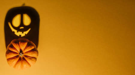 Halloween background concept. Jack O pumpkin angry face shadow. Spooky smiling shadow of an orange pumpkin lantern top view close up, Halloween party designの写真素材