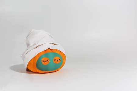 Pumpkin with facial mask and towel isolated on white background. Space for text mockup Spa and Halloween conceptの写真素材