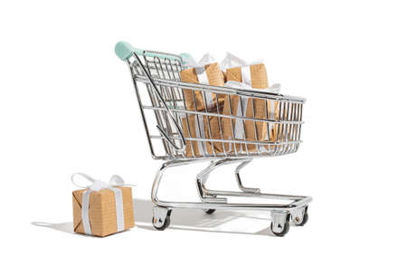 The gift lies in a shopping cart on a white isolated background. Holiday concept of celebration and congratulations, shopping and preparation for the eventの写真素材