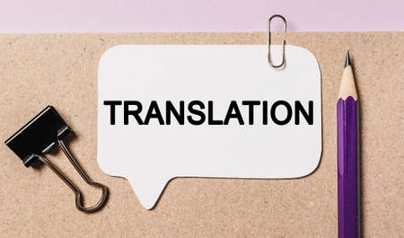 Text TRANSLATION on a white sticker with office stationery background. Flat lay on business, finance and development conceptの写真素材