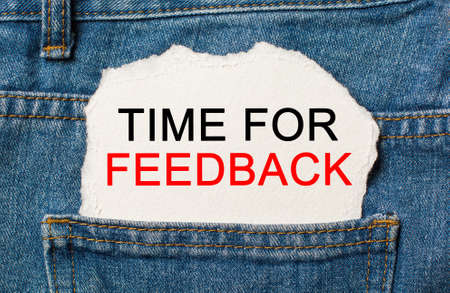 Time for Feedback on torn paper background on jeans business and finance conceptの写真素材