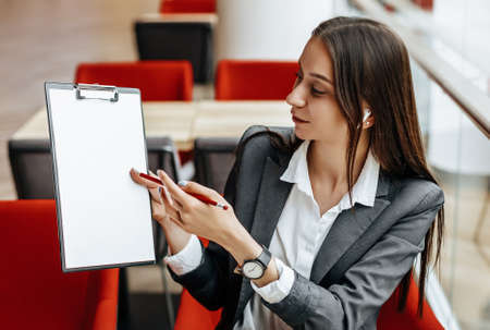 Girl works on a laptop in the workplace. Businesswoman shows and explains the goals and objectives for the business. Successful woman creates a startup and makes decisions.の写真素材