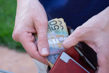 Hands holding wallet with australian dollars and counting money - coronavirus finance struggle conceptの写真素材