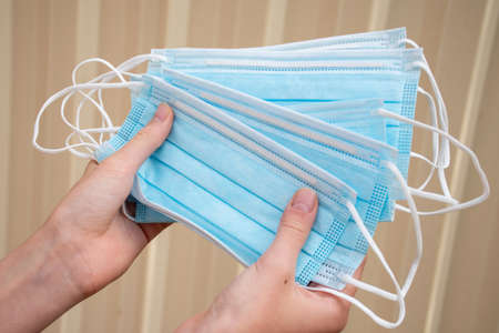Hands holding disposable face mask. Virus deseases and coronavirus COVID-19 conceptの写真素材