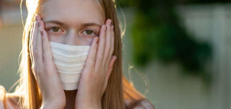 A girl wearing handmade cotton face mask to prevent spreading of the viruses. Coronavirus and...