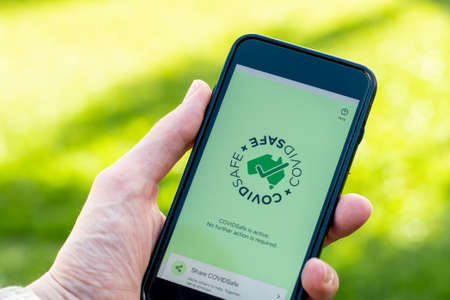 Sydney, Australia 2020-04-26 Hand holding a white smartphone with CovidSafe app. Australian...