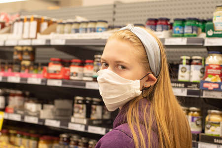 A girl wearing handmade face covering mask at the supermarket.の写真素材