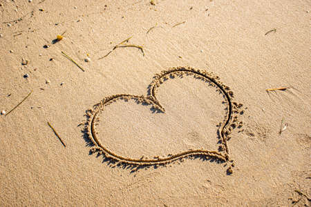 Heart drawn in the sand on the beach. Love and travel concept. Empty space for text inputの写真素材