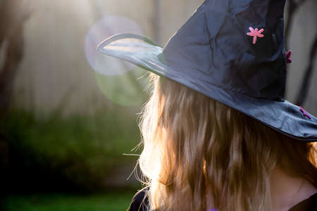 Causcasian blond girl with long hair in halloween witch hat