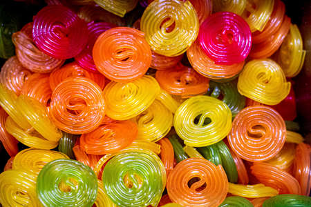 Multicolored jelly swirl candies background - yellow, red, orange transparent rolls . Pick and mix candy shopの写真素材