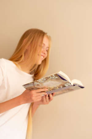 Teenage girl laughing with the book in her hand. Love to read. Selective focusの写真素材