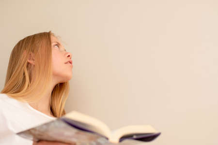 Teenage girl dreaming with the book in her hand. Love to read