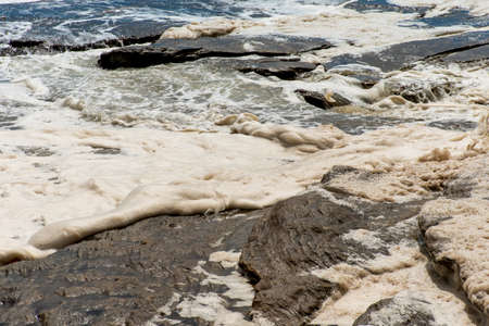 Ocean storm aftermath: A mass of thick foam covered the rocks following extreme storm weather at Cronulla, NSW, Australiaの写真素材