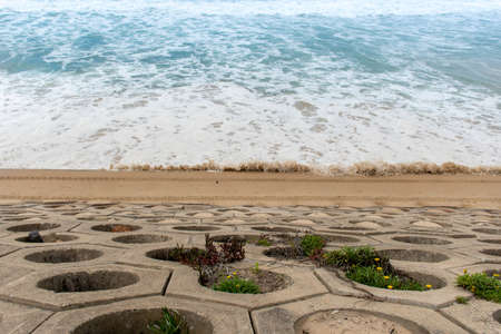 Sea wall exposed after the storm and a sandy beach with high tide at North Cronulla, NSWの写真素材