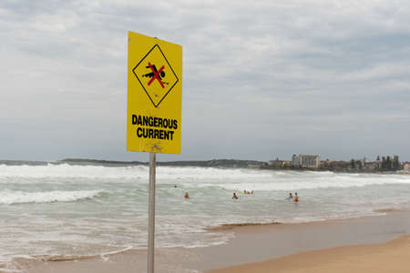 Dangerous current sign for swimmers at the beach in Australia. Despite the warning people are still swimming and surfingの写真素材