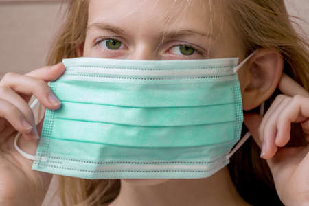 A girl wearing disposable face mask to prevent spreading of the viruses. Coronavirus and COVID-19 Conceptの写真素材
