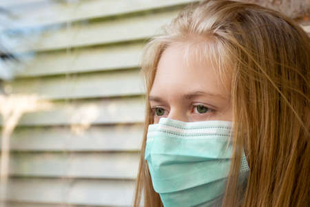 A girl wearing disposable face mask on the street to prevent spreading of the viruses. Coronavirus and COVID-19 Conceptの写真素材