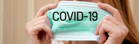 A girl holding disposable face mask to prevent spreading of the viruses. Coronavirus and COVID-19 Conceptの写真素材
