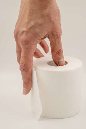 Man's hand holding and giving toilet paper roll.の写真素材