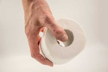 Man's hand holding and giving toilet paper rollの写真素材
