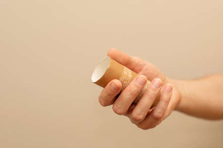 A man's hand holding empty toilet paper rolls. Shortage concept.の写真素材