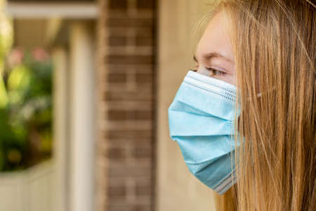 A girl wearing disposable face mask to prevent spreading of the viruses. Coronavirus and COVID-19 Conceptの写真素材