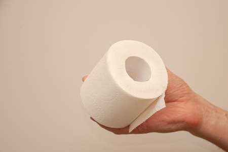 Man's hand holding and giving toilet paper rollの写真素材