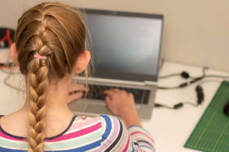 Selective focus image of a teenage girl sitting with her laptop - online learning from home....
