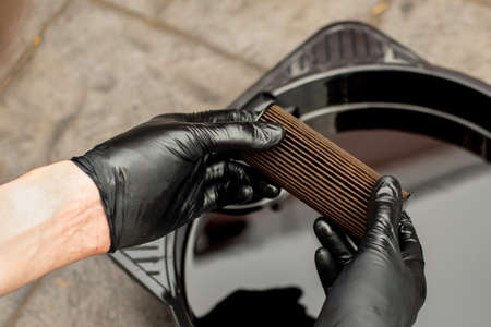 Used drained motor oil in a black tray and used oil filter. DIY change engine motor oil. Disposing...