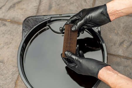 Used drained motor oil in a black tray and used oil filter. DIY change engine motor oil. Disposing of old oilの写真素材