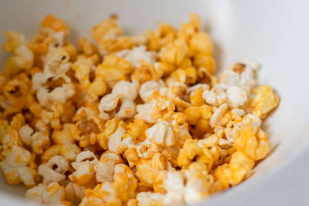Close up of fresh made popcorn in a white bowl. Entertainment at home conceptの写真素材