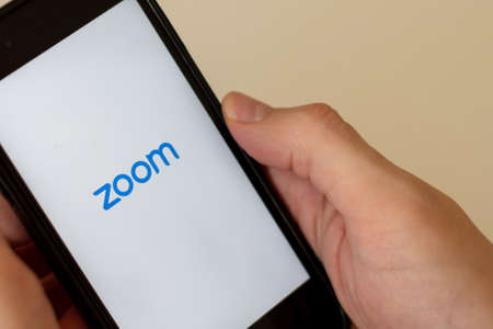 Sydney, Australia - 2020-04-04 Hands holding a phone with zoom application