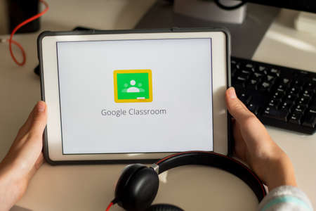 Sydney, Australia - 2020-04-06 Hands holding a tablet with Google Classroom application on screen. Coronavirus lockdown online education conceptのeditorial素材