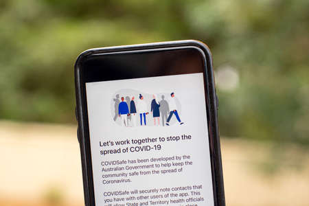 Sydney, Australia 2020-04-26 Hand holding a phone with CovidSafe app. Lets work together to stop the virus. Australian Government introduced new COVID-19 trace tracking appのeditorial素材