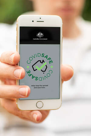 Sydney, Australia 2020-04-26 Hand holding a white smartphone with CovidSafe app. Australian Government introduced new COVID-19 trace tracking appのeditorial素材