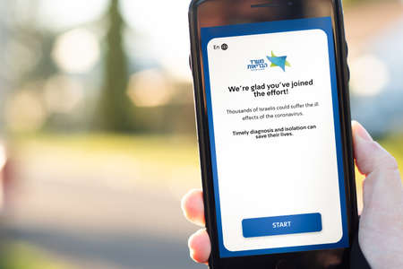 Sydney, Australia, May 2020. Hand holding smartphone with HaMagen app for tracing COVID-19 in Israel. Text in hebrew: Ministry of Health. For a healthier life.のeditorial素材