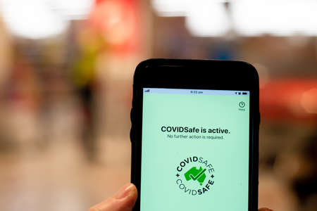 Sydney, Australia 2020-08-07 Hand holding a phone with CovidSafe app. Australian Government COVID-19 trace tracking appのeditorial素材