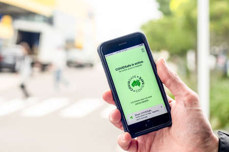 Sydney, Australia 2020-08-07 Hand holding a phone with CovidSafe app. Australian Government COVID-19 trace tracking appのeditorial素材