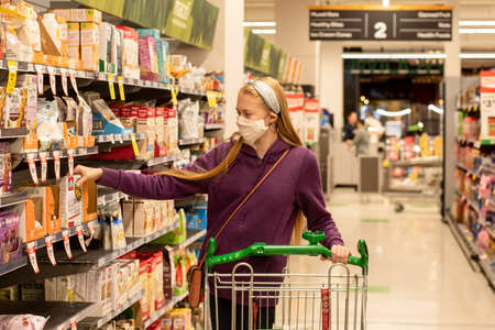 Sydney, Australia - 2020-08-15 A girl wearing handmade face covering mask with the shopping trolley at Woolworths supermarketの写真素材