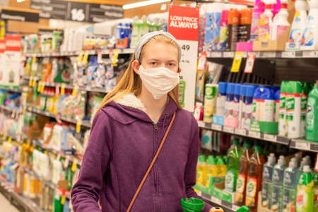 Sydney, Australia - 2020-08-15 A girl wearing handmade face covering mask with shopping trolley at Woolworths supermarketのeditorial素材