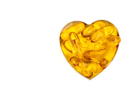 Omega-3 fish oil capsules in a shape of a heart with copy spaceの写真素材