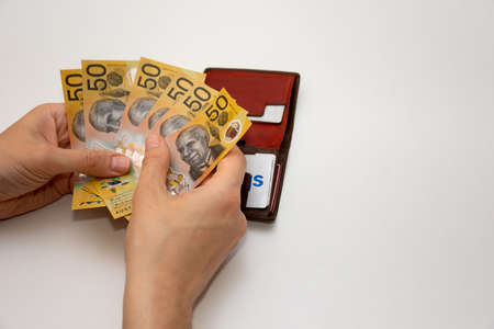 Hands holding leather wallet with australian dollars 50 banknotes. Finance concept with copy space.の写真素材
