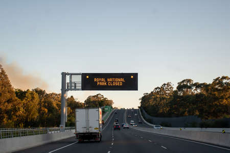Sydney, Australia. 2020-10-10 An out of control bushfire has forced the closure of the Royal National Park in Sydney's south. Smoke from the bushfire is visible left over the road.のeditorial素材