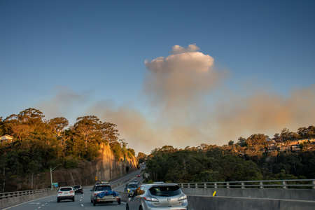 Sydney, Australia. 2020-10-10 Smoke from Royal National Park bushfire visible over the road. The blaze started when hazard reduction burning caused a spot fire which got out of controlのeditorial素材